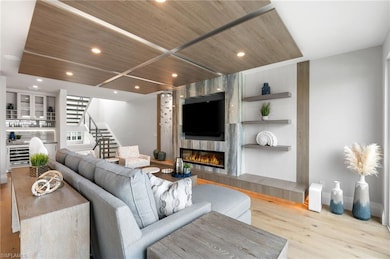 Living area featuring wood finished floors, a tile fireplace, stairs, wooden ceiling, and recessed lighting