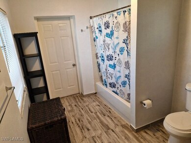 Bathroom with shower / tub combo, baseboards, toil