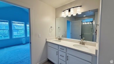 master bathroom featuring a stall shower, double vanity