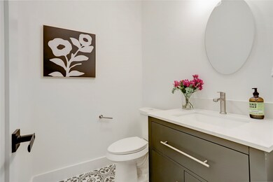 The half bath has custom tile floor, contemporary