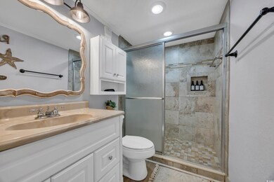 Bathroom with a shower stall, vanity, toilet, tile patterned flooring, and recessed lighting