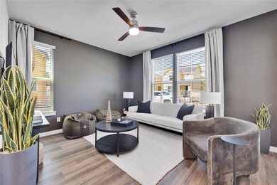 Living area with a ceiling fan, baseboards, and wood finished floors