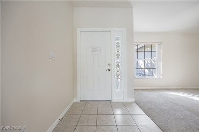 Entrance foyer with light colored carpet