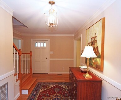 Solid wood door with glass panels, chair molding and stairs to the second floor.