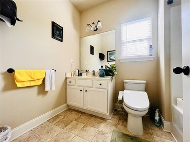 Bathroom with toilet, baseboards, and vanity