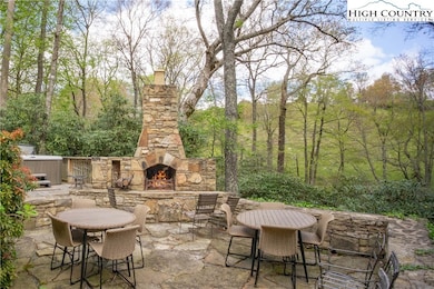 Stone patio with wood burning fireplace and hot tu