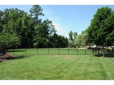 The flat and open rear yard is partially fenced an
