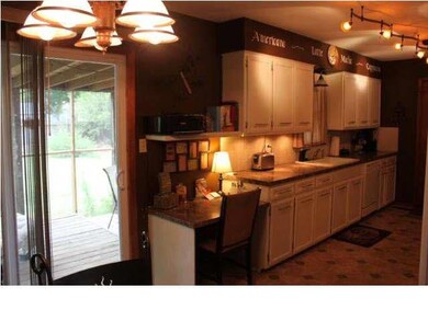 Kitchen has planning desk, door to screened in por