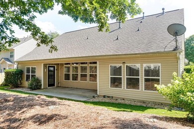Rear view of house featuring a shingled roof and a patio area
