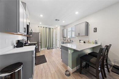 Kitchen with light wood finished floors, a breakfa
