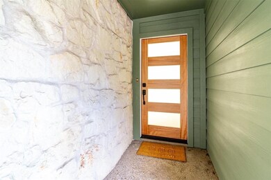 Doorway to property with stone siding