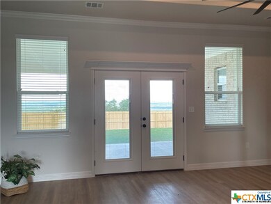 Window-flanked French doors open to the huge cover