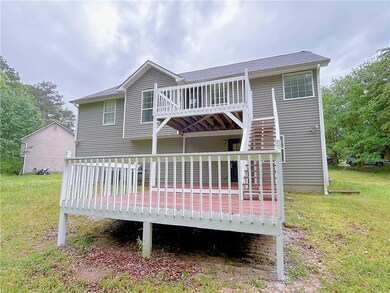 Back of house featuring a yard and a wooden deck