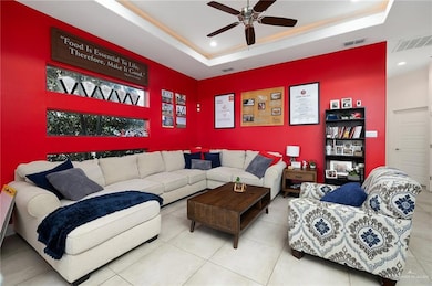 Tiled living room with a raised ceiling and ceiling fan