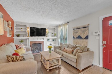 The living room features custom built in shelving surrounding the fireplace