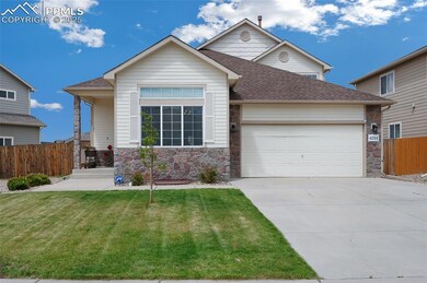 View of front facade featuring an attached garage, stone siding, concrete driveway, and roof with shingles