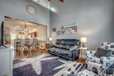 Living area featuring wood finished floors and a towering ceiling