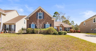 Traditional-style home with a front lawn and brick