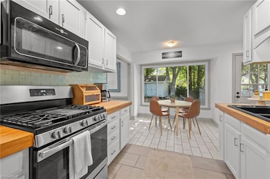 Updated kitchen with butcher block counters, tile backsplash and gorgeous views of the backyard.