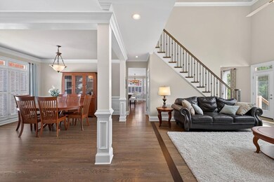 Living area featuring stairs, crown molding, dark wood-type flooring, recessed lighting, and a chandelier