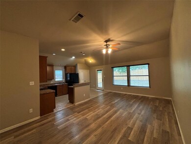 Kitchen with a kitchen island, ceiling fan, tile patterned floors, black appliances, and vaulted ceiling
