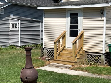 Entrance to property featuring a shingled roof and a yard