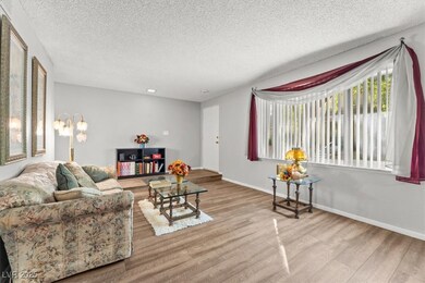 Living area with a textured ceiling and light wood-style floors