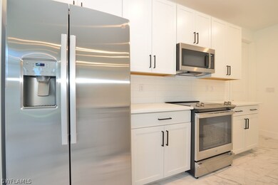 Kitchen featuring white cabinets, tasteful backsplash, and appliances with stainless steel finishes