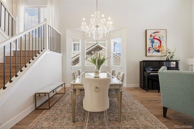 An elegant dining area bathed in natural light, with updated hardwood floors and crowned with a dazzling chandelier.