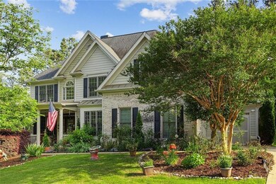 View of front facade featuring a front yard, a standing seam roof, brick siding, and metal roof
