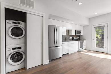 Washroom with laundry area, stacked washing machi