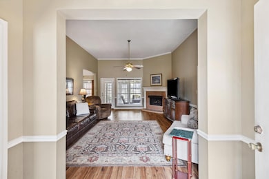 Living area with a brick fireplace, crown molding,
