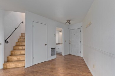 Hallway featuring wood finished floors, stairs, and heating unit