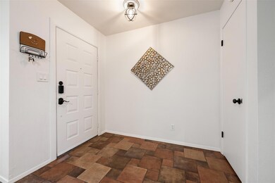 Foyer featuring dark stone finish flooring and ba