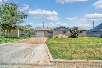 Single story home featuring brick siding, a garage, and concrete driveway