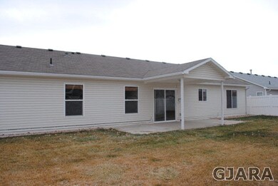 Back of home with covered patio.