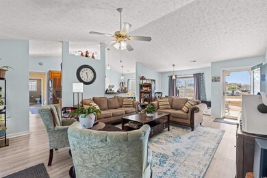 Living room with a textured ceiling, light hardwoo