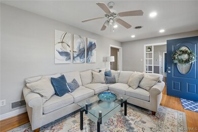 Living room with light hardwood flooring and ceiling fan