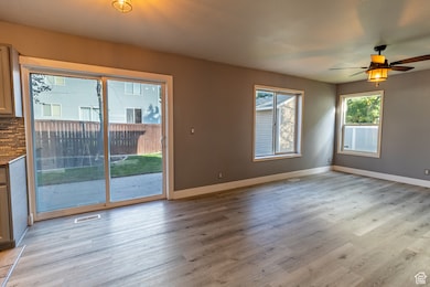 Unfurnished living room featuring light wood finished floors and a ceiling fan