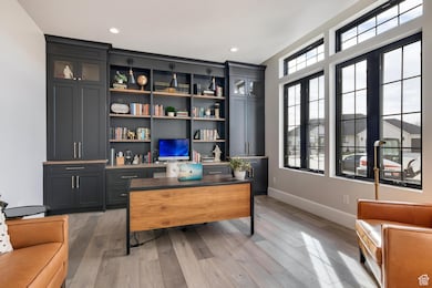 Office space featuring light wood finished floors and recessed lighting