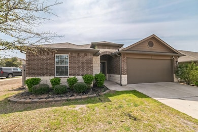 Ranch-style home with brick siding, concrete driveway, roof with shingles, a front yard, and an attached garage