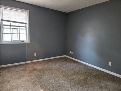Empty room featuring carpet, baseboards, and a textured ceiling