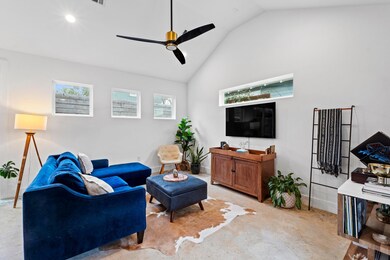 Living area with light colored carpet, baseboards