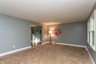 Large living room has new carpet and fresh paint.