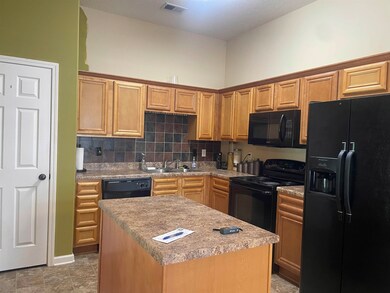 Kitchen featuring black appliances, a center islan