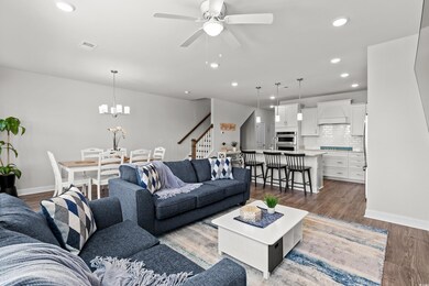 Living room with baseboards, ceiling fan, stairs, 