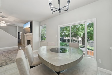 Dining area with a tiled fireplace, a chandelier,