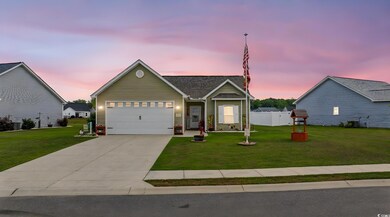 View of front facade featuring driveway and a gara