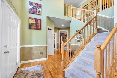 Two-story entry with hardwood floors in foyer, pow