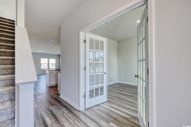 Corridor featuring wood finished floors, baseboard